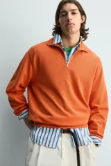 Sudadera regular fit azul marino confeccionada en tejido de algodón con estructura piqué. Cuenta con cuello subido, cierre frontal de cremallera corta y mangas largas con acabados en rib.