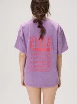 Remera oversize de corte cuadrado, color lila con efecto acid wash, cuello redondo y pequeño gráfico frontal en color rojo.