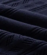 Polo de punto azul marino para hombre, confeccionada en algodón con textura de rayas verticales y patrón en zigzag, cuello polo con cierre frontal parcial y mangas cortas.