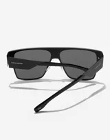 Lentes de sol Hawkers modelo Long Island, unisex, con montura cuadrada negra y lentes grises.