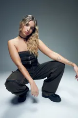 Top strapless de denim gris con diseño estilo corset, presenta doble tira ajustable con hebillas metálicas en el frente y cierre en la espalda.