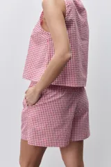 Short de tiro medio con estampado de cuadros vichy rojo y blanco, silueta relajada, bolsillos laterales y cintura elastizada en la parte trasera.