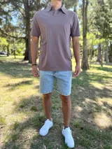 Remera polo de manga corta color marrón vizón, con cuello camisero y cierre frontal de dos botones.
