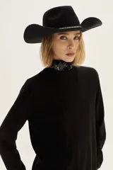 Sweater de punto color beige, con cuello redondo, manga larga y puños acanalados.