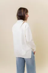 Sweater de tejido de punto color marrón, con cuello alto, corte relajado y terminaciones en rib en puños y cintura. Presenta una hilera de botones metálicos decorativos en uno de los laterales.