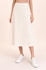 Falda midi de punto en color off white, con cintura elástica y corte acampanado.