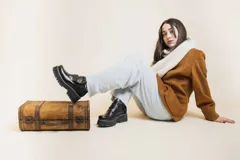 Botas cortas de cuero negro con ajuste mediante hebillas y suela track.