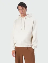 Buzo con capucha de color blanco hueso, corte holgado, con cordones ajustables en el cuello y elástico fruncido en el bajo. Presenta un pequeño logo bordado en el pecho.