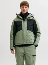 Campera técnica impermeable y cortaviento con capucha ajustable, diseñada para condiciones de frío, viento y lluvia. Confeccionada en tejido resistente, cuenta con cierre frontal con tapeta, bolsillos con cierre, ventilación bajo los brazos y ajustes en puños para evitar la entrada de nieve.