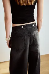 Jeans de tiro medio y diseño balloon, color azul denim con efecto lavado, cinco bolsillos, cierre frontal con cremallera y botón metálico, y bajos acabados en puño.