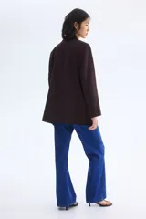 Blazer de sarga color bordó con solapas de pico, frente abierto y bolsillos delanteros ribeteados con solapa.