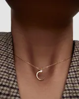 Collar de Pdpaola con cadena de eslabones y colgante en forma de letra C dorada con una circonita incrustada.