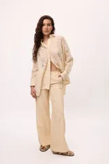 Camisa color crema de encaje con cuello clásico, manga larga con puños abotonados y corte oversize.