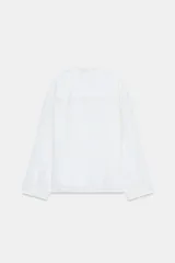 Camisa blanca de lino 100% con cuello solapa de muescas, manga larga y bajo asimétrico. Cierre frontal con botones.