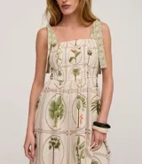 Vestido midi de corte evasé confeccionado en viscolino (mezcla de viscosa y lino). Presenta un diseño con estampado de palmeras y follaje sobre un fondo beige. Cuenta con escote cuadrado, breteles anchos con lazos ajustables en los hombros y espalda con lastex para un ajuste cómodo.