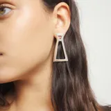 Pendientes de diseño geométrico minimalista con forma trapezoidal calada, fabricados en aleación de metales con baño de plata de ley.