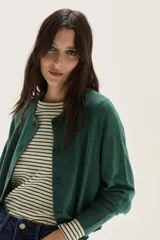 Cardigan de tejido de punto en color azul, con cuello redondo, cierre frontal con botones al tono y mangas largas con puños acanalados. Presenta un diseño clásico y versátil.