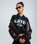Buzo de punto con diseño de rayas verticales en azul marino y verde, cuello tipo polo y estampado frontal con la inscripción 'PLAYER CLUB'. Presenta un corte regular y mangas largas.