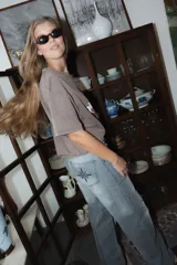 Jean de corte recto y tiro medio, con costuras verticales decorativas en el frente y bordado de brújula en los bolsillos traseros.