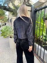Conjunto de dos piezas confeccionado en tejido plush ultra suave, compuesto por un buzo cropped de corte relajado y un pantalón recto con bolsillos funcionales.