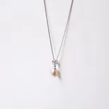 Conjunto compuesto por collar y anillo de plata 925. El collar presenta una cadena fina con un dije de perla de río natural y una circonia engarzada. El anillo a juego cuenta con una perla de río central.