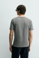 Camiseta de corte ajustado confeccionada en tejido de algodón con elasticidad, cuello redondo y manga corta.