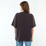 Camiseta de corte oversize color negro, con cuello redondo y mangas cortas. Presenta un estampado frontal en color crema con el logo de la banda Queen, rodeado de motivos florales y una corona.