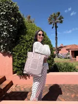 Bolso tote grande de símil cuero negro, con asas dobles y correa ajustable. Presenta un bolsillo frontal con borde en relieve.