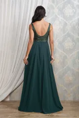 Vestido largo de fiesta color verde esmeralda, con cuerpo sin mangas bordado en lentejuelas y cuentas, escote en V y falda fluida con tajo lateral profundo.