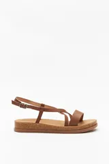 Sandalias marrones con tiras cruzadas y hebilla ajustable, suela de corcho.