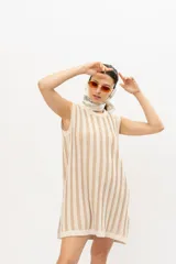 Vestido corto de punto con rayas verticales en tonos beige y crema, sin mangas y cuello redondo.