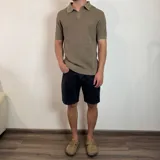 Chomba de tejido de punto con textura, color beige, de manga corta y cuello polo con cierre frontal parcial.