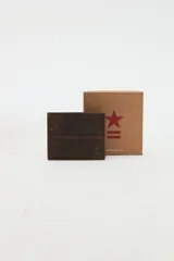 Billetera combinada en cuero marrón con costuras decorativas y pequeño aplique metálico de estrella y líneas en el frente. Interior con compartimentos y forro de algodón.