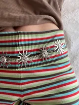 Cadena plateada para cintura con dijes de soles sonrientes.