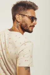 Remera de cuello redondo y manga corta, color beige con estampado de pequeños motivos playeros.