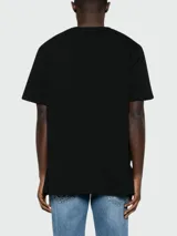 Remera de algodón negra de corte clásico, con cuello redondo y mangas cortas. Presenta el logo de la marca Balmain bordado en relieve en el frente.