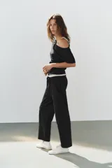 Pantalón de algodón negro con tiro medio, cintura elástica, pierna recta y grandes bolsillos laterales aplicados.