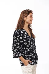 Blusa negra con estampado floral blanco, escote en V y mangas 3/4 con volados.
