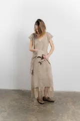 Vestido largo tejido color beige, con diseño en bloques de rombos, escote en V y flecos en el ruedo.