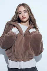 Campera de piel sintética color marrón, con cierre frontal, cuello alto y diseño holgado.