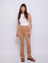 Pantalón negro de tela elastizada con corte central en las piernas, cierre y botón de plástico.