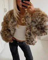Chaqueta de pelo sintético con estampado animal print en tonos beige y marrón, de corte oversized y textura suave, con interior forrado y cierre frontal oculto.