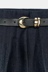 Pantalón de tiro alto y corte tobillero, confeccionado en tejido de aspecto denim oscuro. Presenta diseño de pinzas frontales, bolsillos laterales y cierre frontal con cremallera, botón y gancho. Incluye un cinturón fino a tono con hebilla metálica dorada.