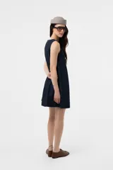 Vestido corto sin mangas de denim negro, con silueta evasé, calce suelto y costuras pespunteadas a contratono.
