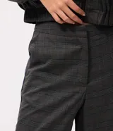 Pantalón de sastrería de corte recto y tiro medio, con estampa a cuadros en tonos de gris. Cuenta con cierre frontal discreto y detalles laterales contrastantes.