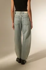 Pantalon de jean estilo baggy, color celeste lavado, con detalle de tachas metálicas en los bolsillos delanteros y a lo largo de las costuras laterales. Presenta un corte ancho y tiro bajo.