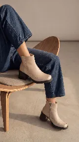 Bota corta de cuero negro con acabado brillante, diseño minimalista, taco cuadrado medio y plataforma delantera. Cuenta con cierre lateral interno para facilitar el calce.