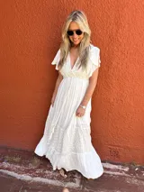 Vestido largo color crudo, de seda con bordados en el mismo tono, escote en V, mangas cortas con volados y corte imperio.