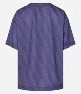 Remera oversized de tule con estampado geométrico en tonos azul y borgoña. Presenta cuello redondo, mangas cortas y estampado frontal con letras.