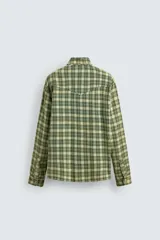 Camisa de corte relajado confeccionada en tejido de algodón con estampado de cuadros en tonos verdes y beige. Presenta cuello solapa, cierre frontal con botones a presión, bolsillos plastrón en el pecho y mangas largas con puños abotonados.
